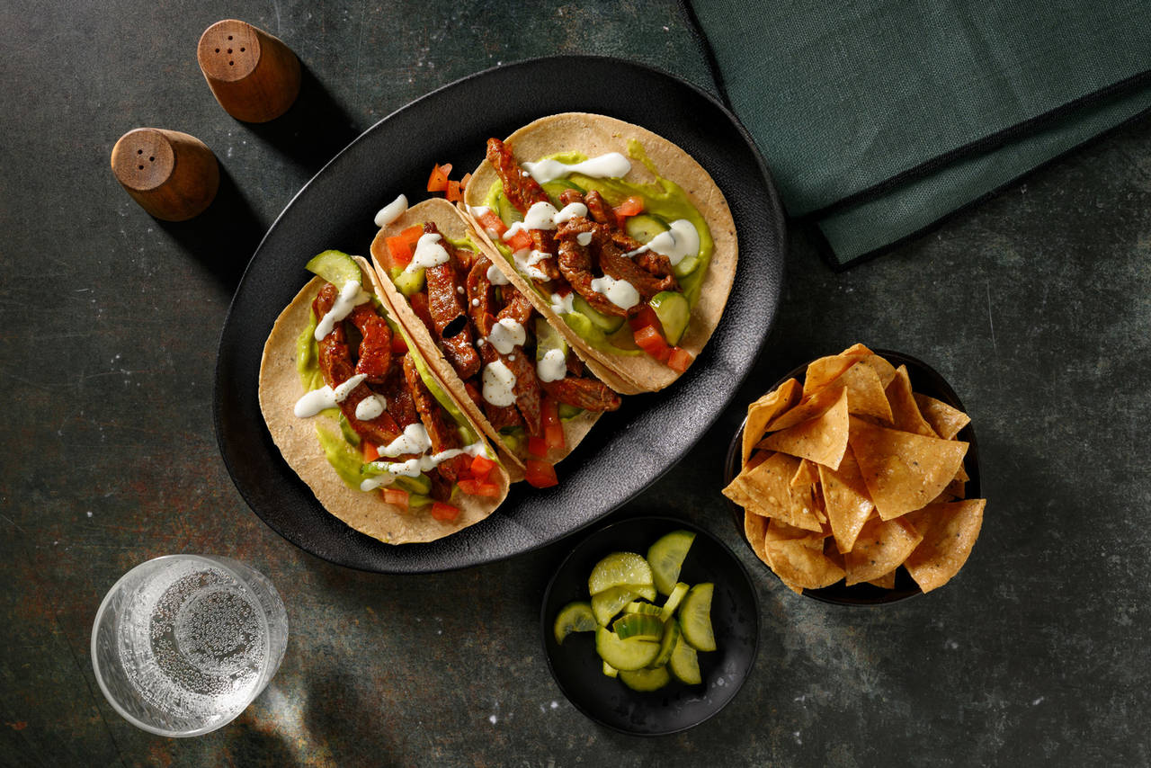 Tacos de ternera con harissa y miel con guacamole, pepino encurtido y tomate