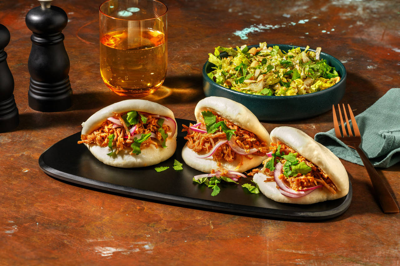 Baos de pulled pork con cebolla encurtida acompañados de ensalada con cacahuetes