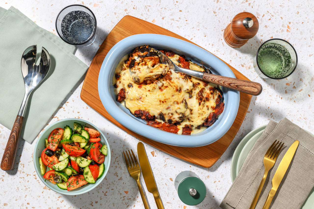 Moussaka griega de ternera y berenjena con ensalada de pepino, tomate y olivas