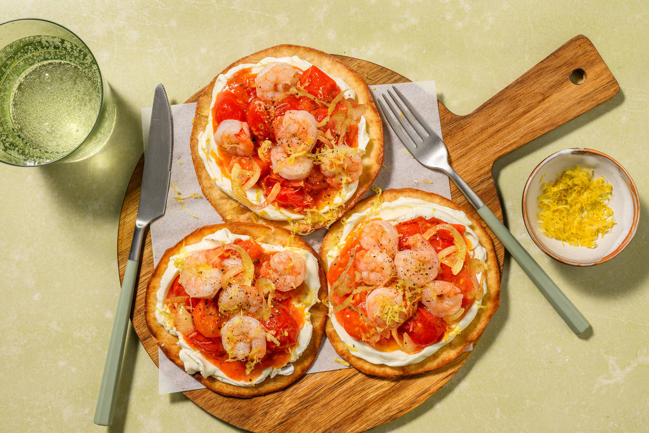 Tostadas crujientes de langostinos con salsa cítrica con tomates cherry y cebolla salteados
