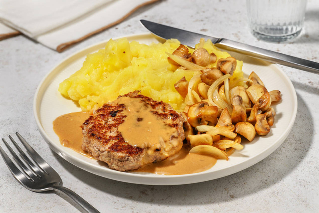 Hamburguesa de cerdo con salsa cremosa de mostaza con puré de patatas y champiñones salteados