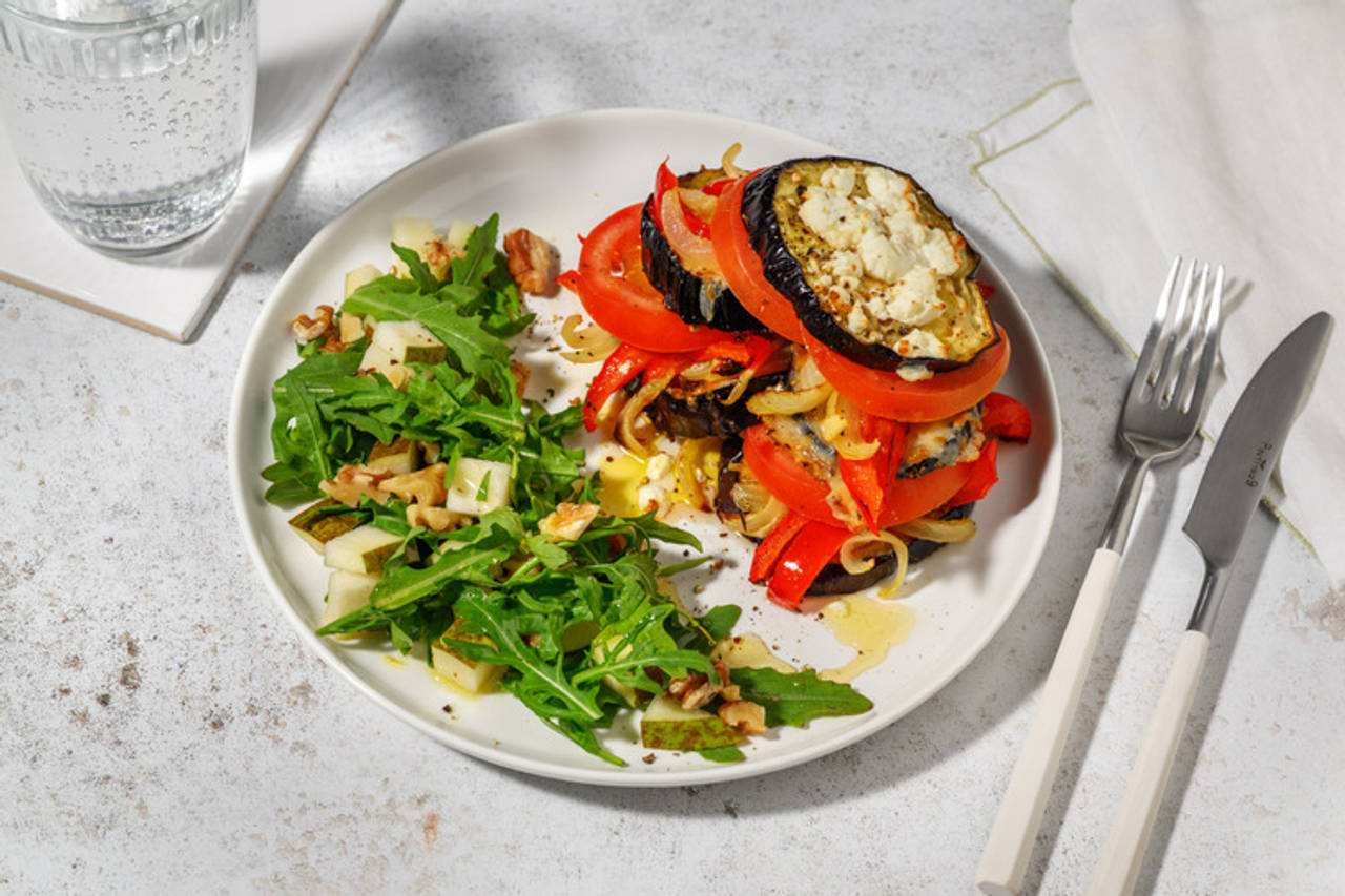Timbal de berenjena asada con queso de cabra y tomate con vinagreta de ajo asado y miel y ensalada