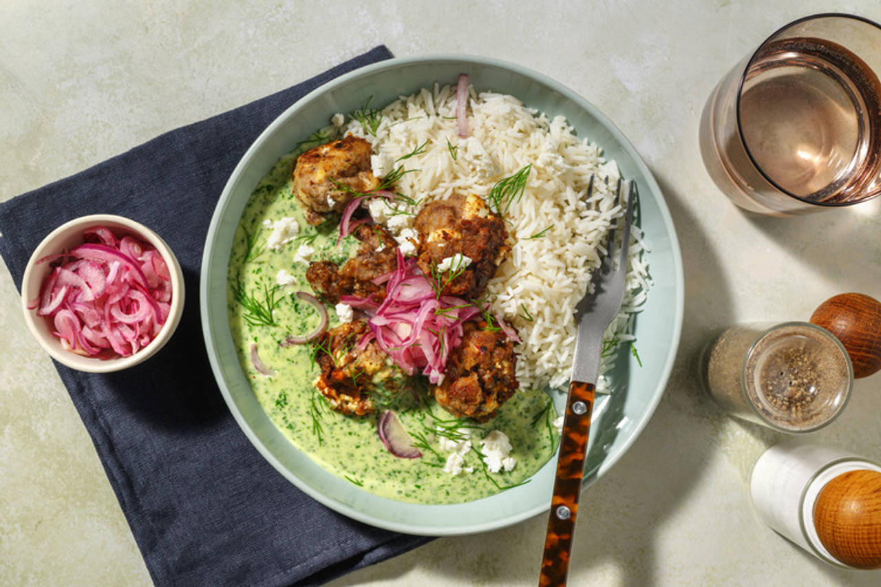Albóndigas con queso griego en salsa de eneldo con cebolla encurtida y arroz