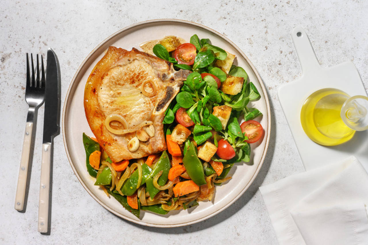 ¡Al ajillo! Chuletas de cerdo con verduritas salteadas acompañadas de ensalada con picatostes