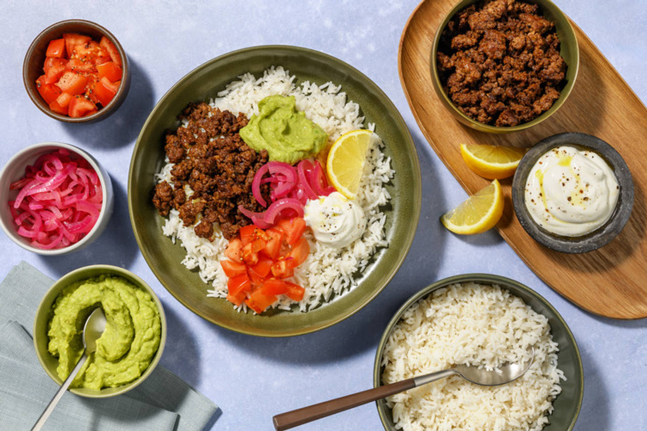 Burrito bowl de ternera y guacamole con cebolla encurtida, tomate, yogur y limón sobre arroz