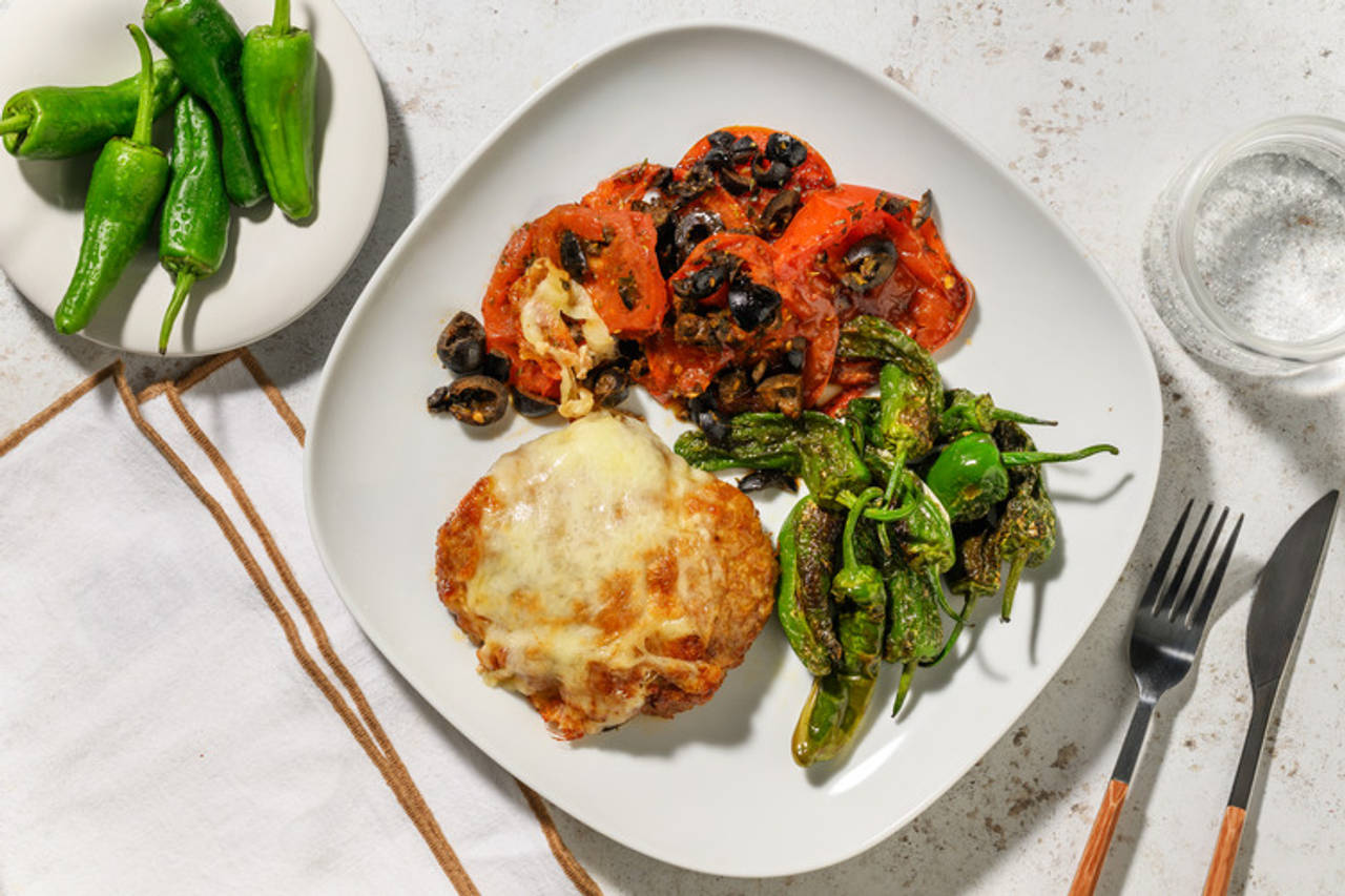 Hamburguesa con queso fundido y pimientos de padrón con tomate y olivas negras a la crema balsámica