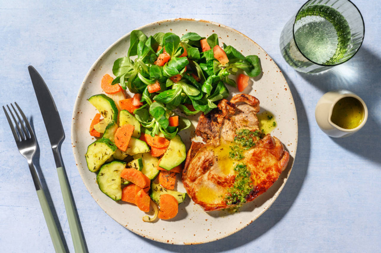 Extra de chuleta de cerdo con chimichurri cítrico con verduras salteadas y ensalada fresca de canónigos