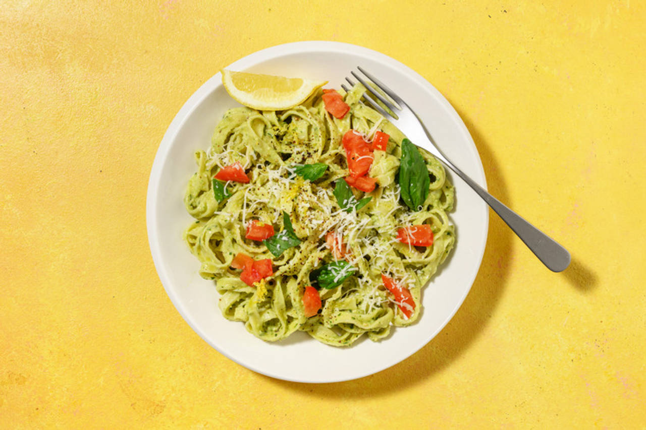 Tagliatelle al pesto cítrico de aguacate con albahaca con tomate y pecorino italiano
