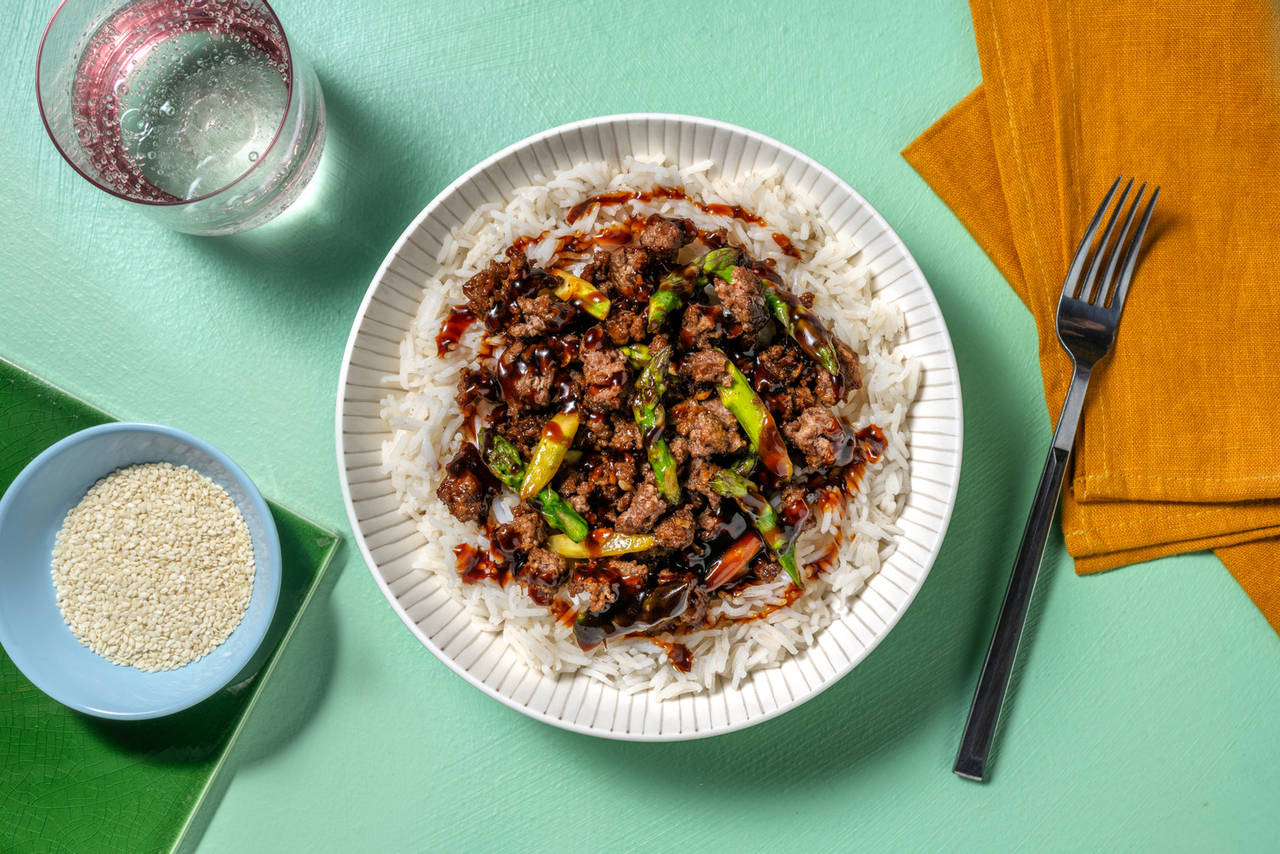 Bol de ternera estilo asiático con espárragos verdes sobre arroz jazmín