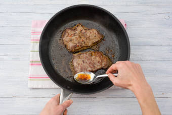 Cook and baste the steaks with the marinade