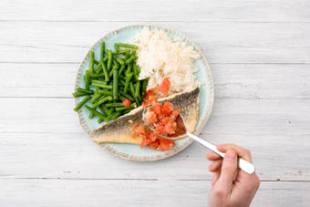 Leg op elke zeebaarsfilet een lepel tomatensalsa.