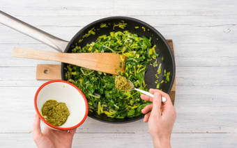 Voeg de groene pesto toe.