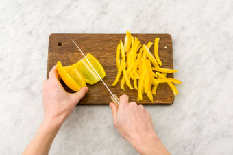 Verwijder de zaadlijsten van de gele paprika en snijd in dunne repen.