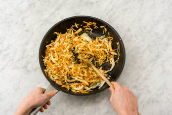 Voeg de mix van Chinese kool en peen, korianderzaad, ketjap, witte wijnazijn toe.