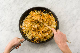 Voeg de rijst en kipfiletreepjes toe.