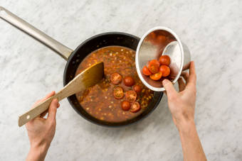 Voeg halverwege de cherrytomaten toe.