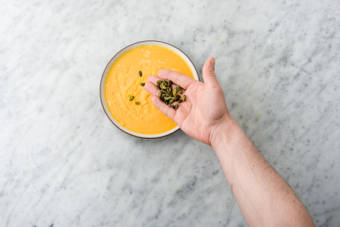 Garneer met de pompoenpitten en overige grana padano.