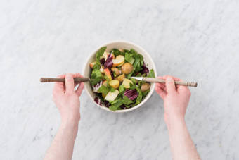 Verdeel de dressing over de salade.