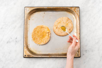 Besprenkel de pitabroodjes met een beetje water en bestrooi eventueel met wat overgehouden currykruiden.