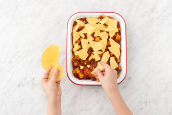 Émiettez les coquilles à tacos au-dessus du plat.