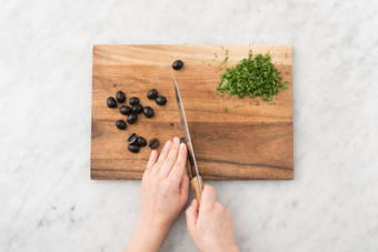 Ciseler la coriandre et coupez les olives en deux.