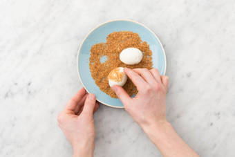 Retirez-la du wok et roulez l’œuf dans la poudre