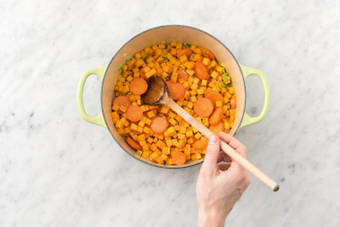 Faire revenir l’ail, la carotte, les dés de courge, les épices pour curry et le reste de jeunes oignons