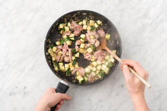 Cuire la courgette, les dés de filet de cuisse et les noisettes