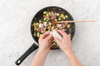 Émietter le chèvre au-dessus du wok