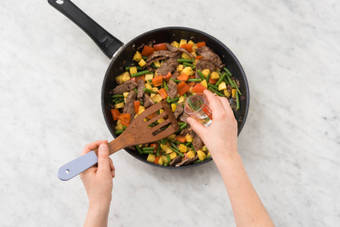 Kartoffelwürfel, Bohnen- und Paprikastücke und Gewürzmischung dazugeben