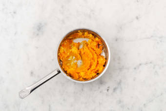 Schiacciare le patate e la zucca 