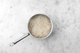 Combina los fideos y la salsa