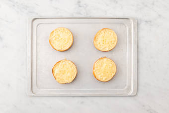 Toast buns and melt cheese