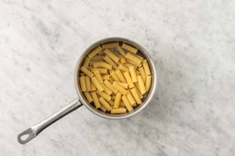 Cuocere la pasta e sbollentare la rucola