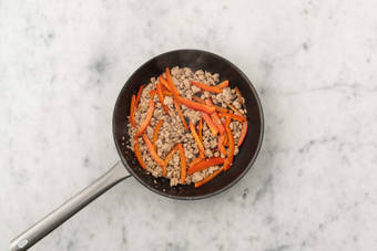 Cook plant-based protein shreds and peppers