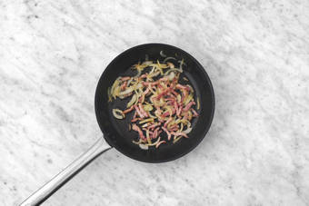 Cuocere le cipolle e la pancetta