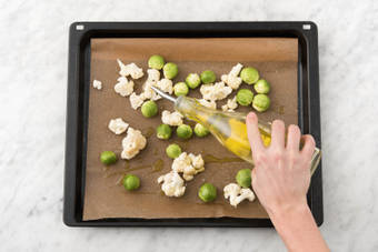 Besprenkel de groenten met de olijfolie.