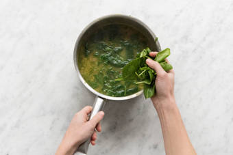 Babyspinat in den Topf geben