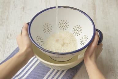 Place the rice into a sieve and rinse it with cold tap water