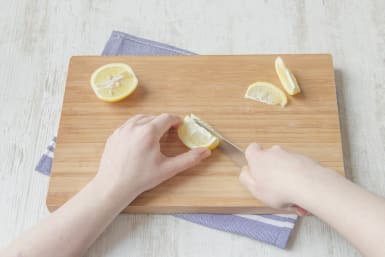 Zitrone in feine Spalten schneiden