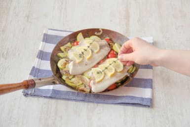 Place tilapia over vegetables and top with lemons