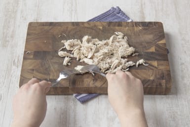 Using two forks pull the meat of the chicken apart into strands