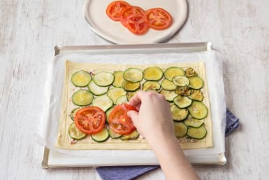 Place the courgette and tomato slices on top of the tart