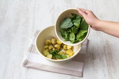 Toss the cooked new potatoes together with the spinach and the dressing
