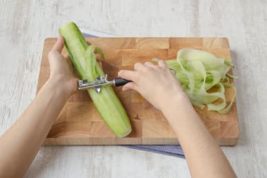 Peel cucumber into strips