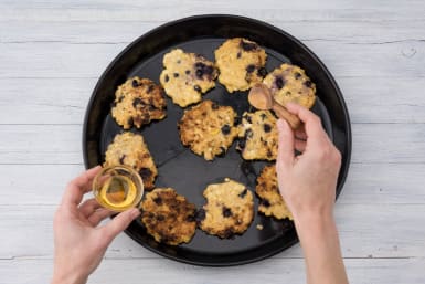 Schenk de honing over de pannenkoekjes.