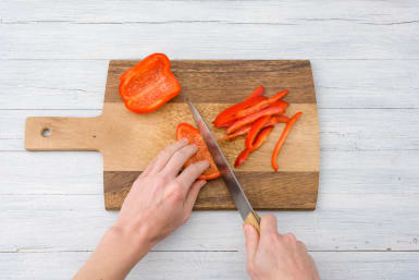 Verwijder de zaadlijsten en snijd de paprika in repen.