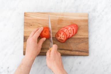 Snijd de tomaat in plakken.