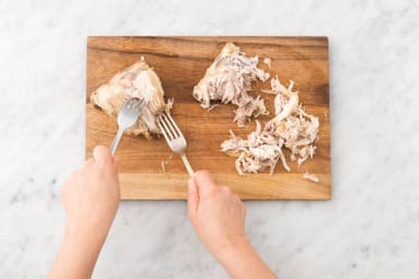 Trek het vlees met behulp van twee vorken van het bot en snijd fijn