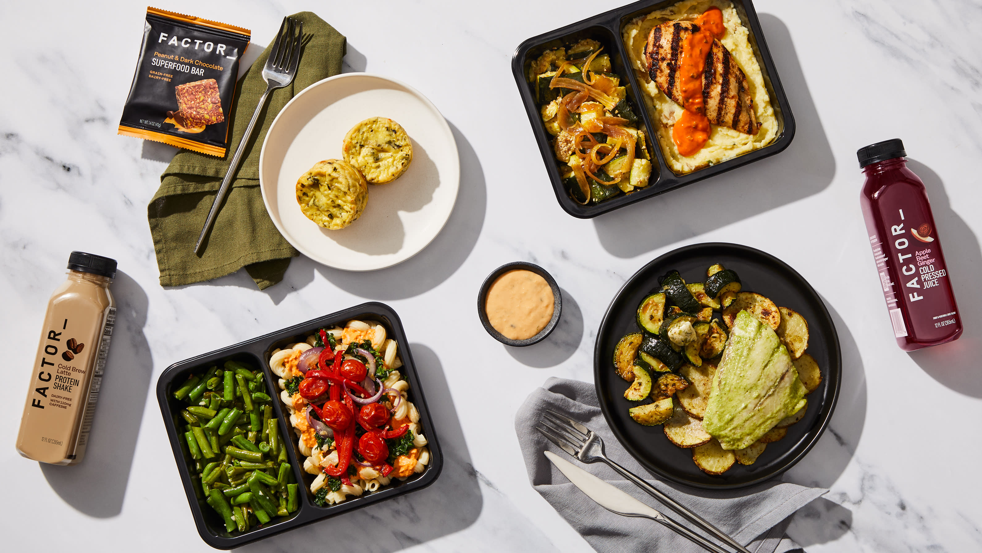 Factor meal tray with pasta and green beans, served with egg bites, a protein shake, and a superfood bar.